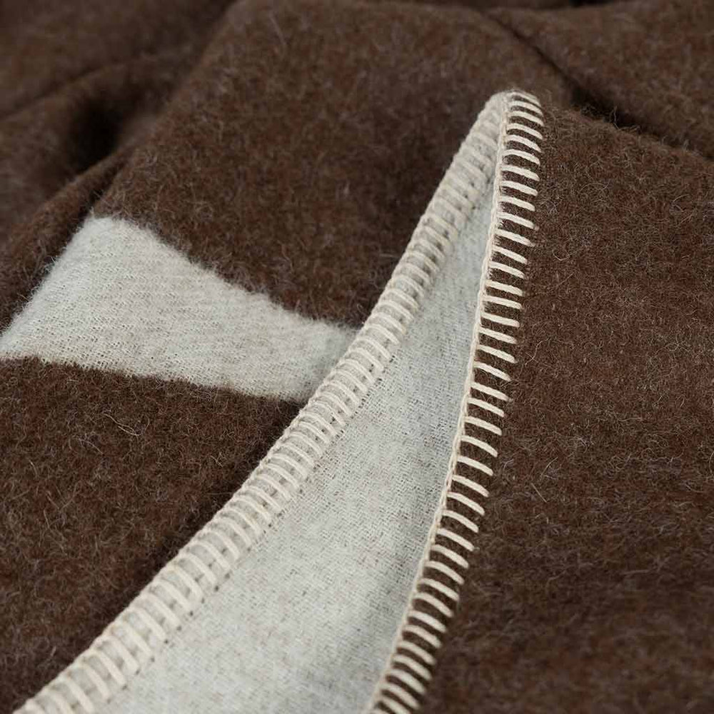 Berlin reversible throw showing rolled hem with ivory blanket stitching