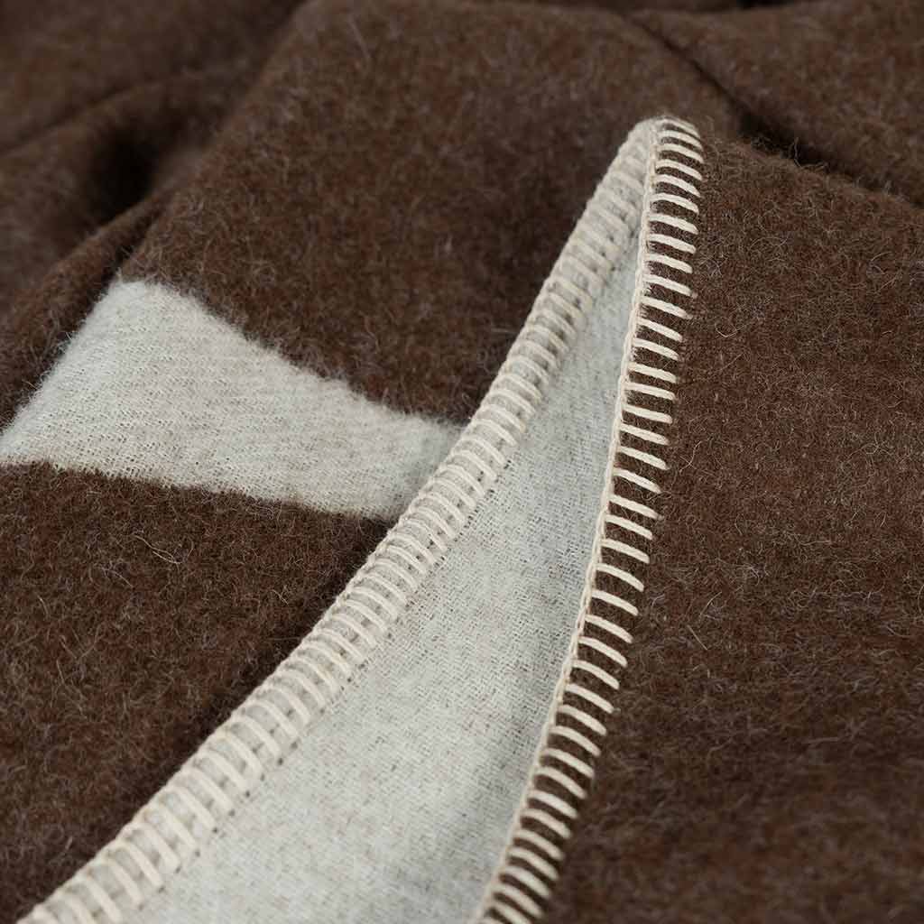 Berlin reversible throw showing rolled hem with ivory blanket stitching