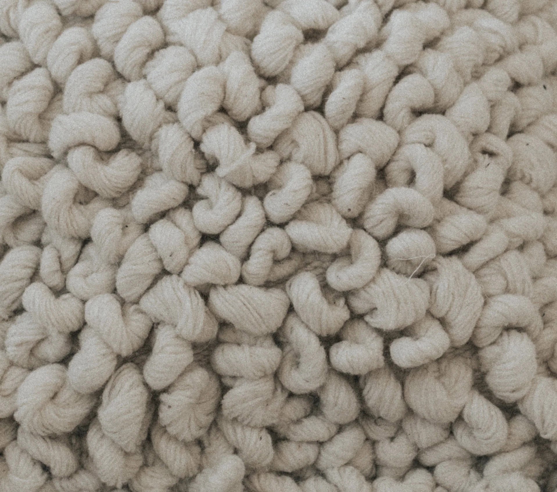 Beige throw pillows with oversized chunky loops and warm neutral tone