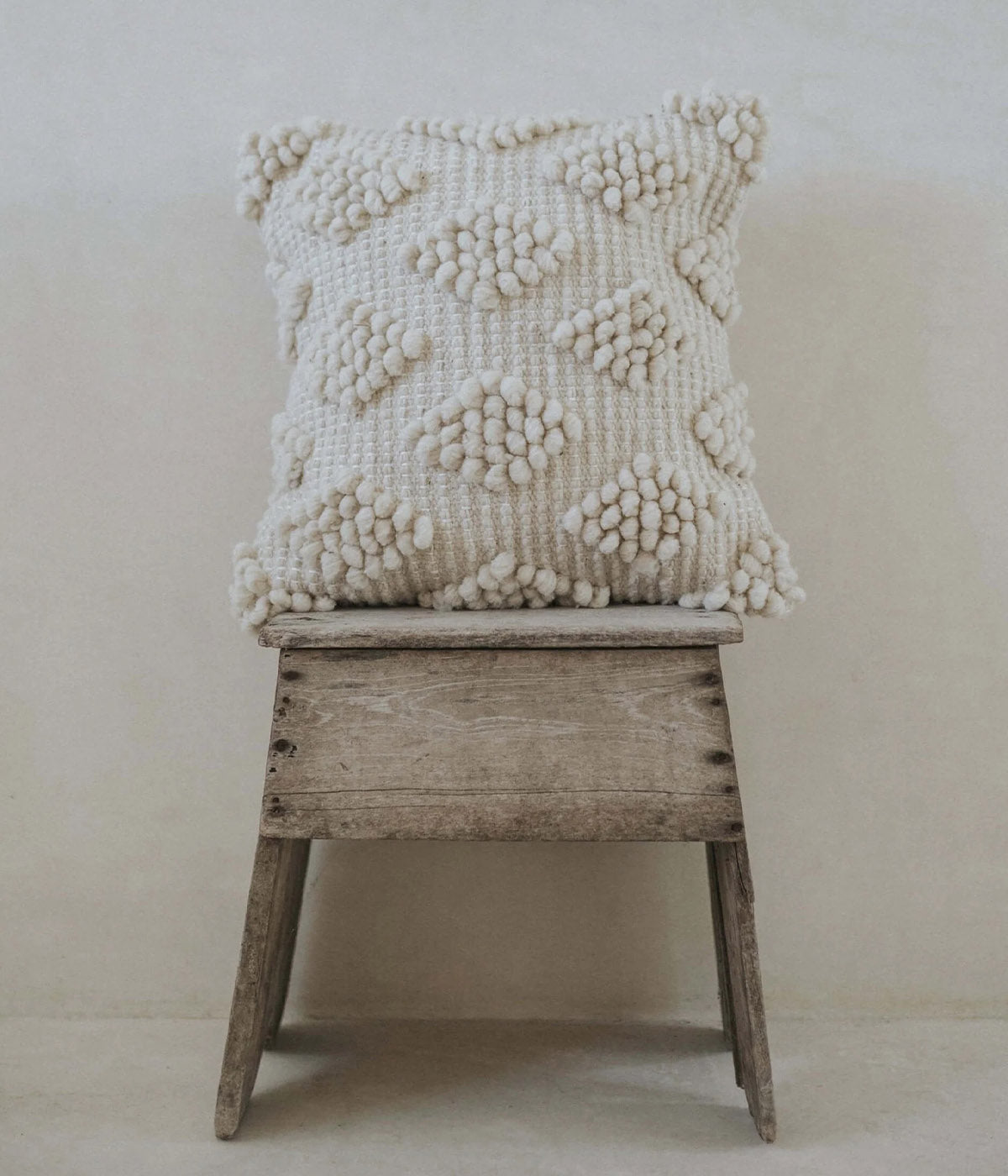 Cream throw pillows with hand-formed bobble clusters