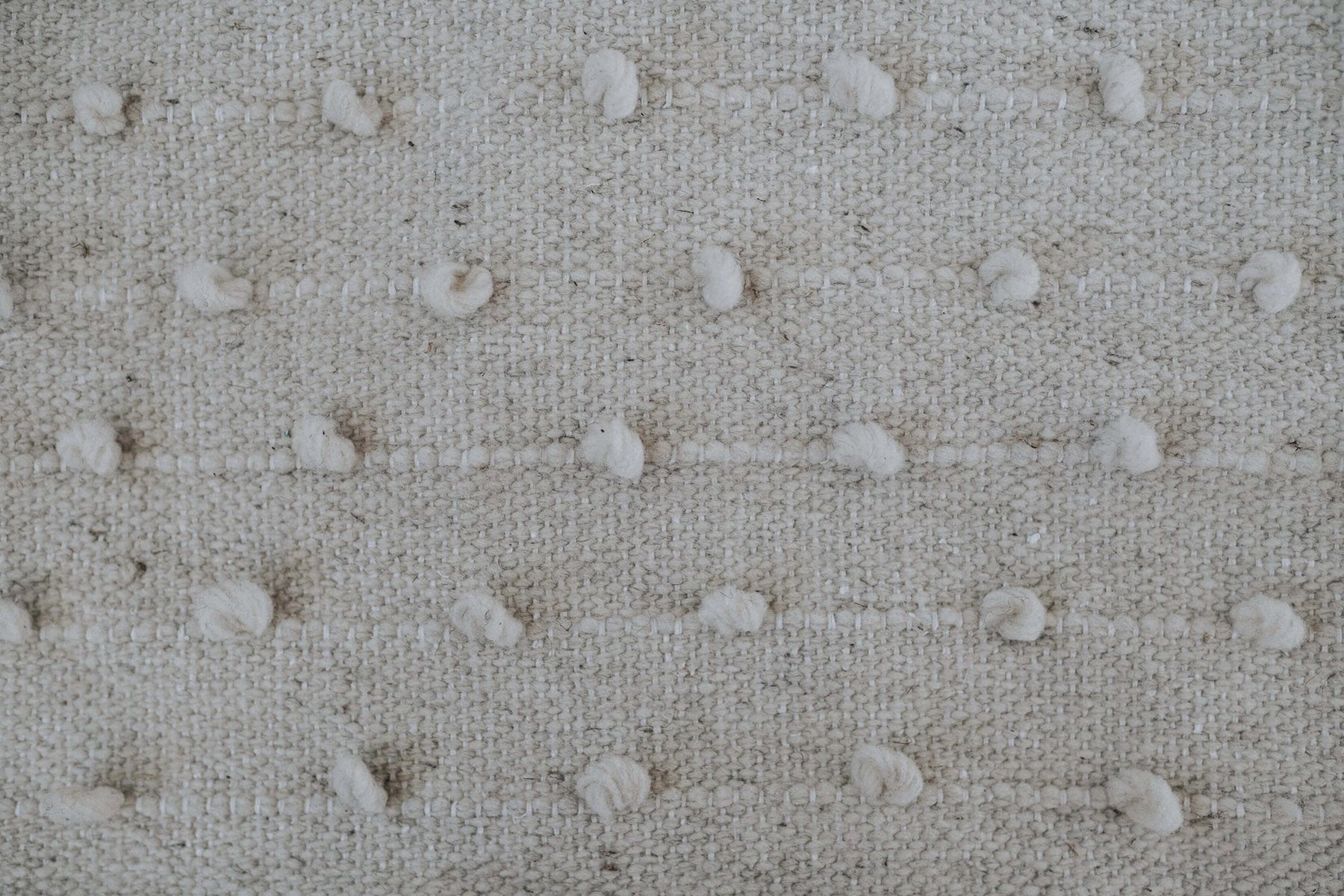 Natural fiber throw pillows with individually placed textured dots