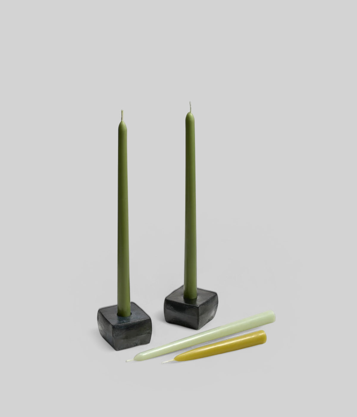 Tall antique green taper candles 12 inch in ceramic holders on dining table