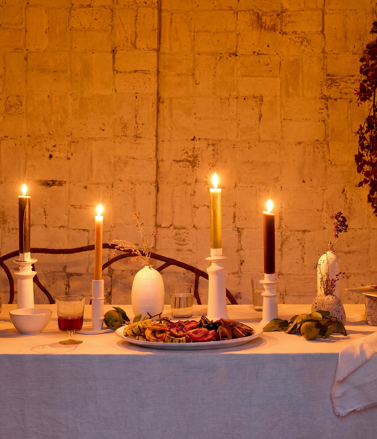 Hand-thrown stoneware platter with natural glaze variation set on a candlelit dinner table