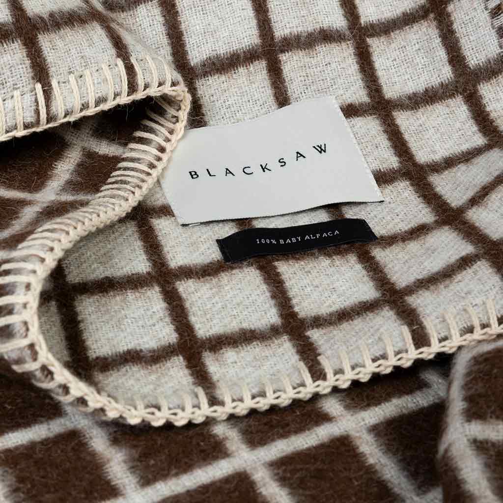 Floyd reversible throw showing ivory and coffee faces at folded corner