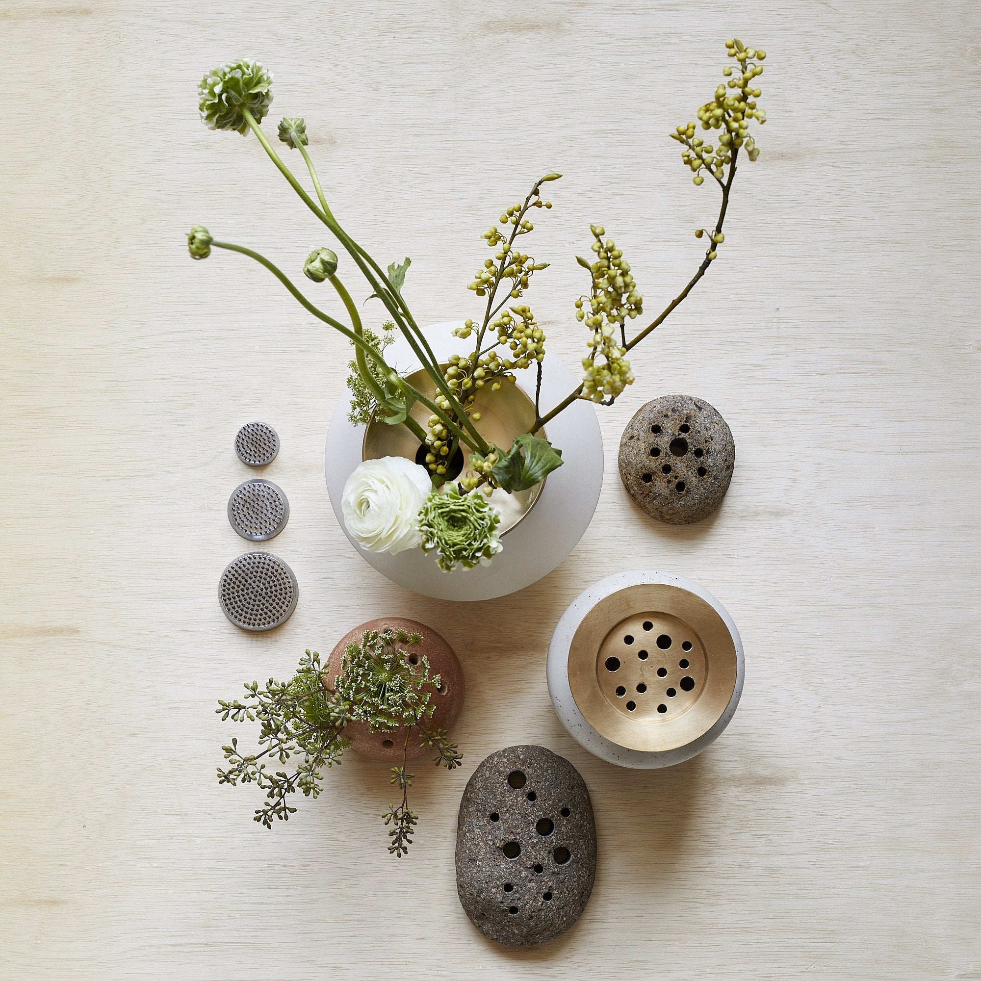 Multiple frog vases with fresh flowers on wood surface