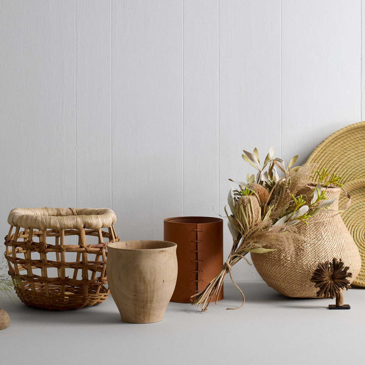 Decorative setup featuring woven baskets, dried flowers, and ceramic vases