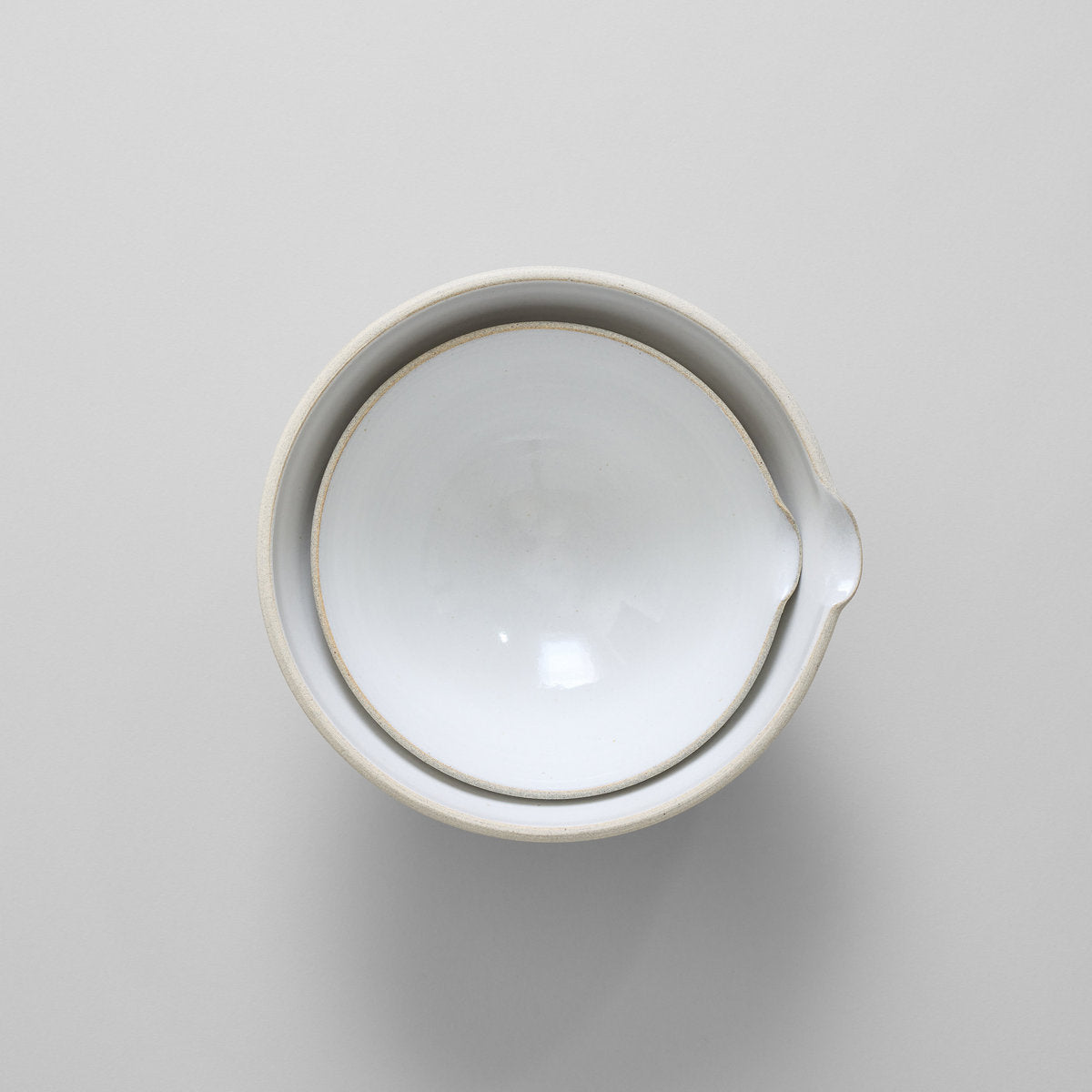 Small and large mixing pour bowl with white glaze interior and textured clay exterior