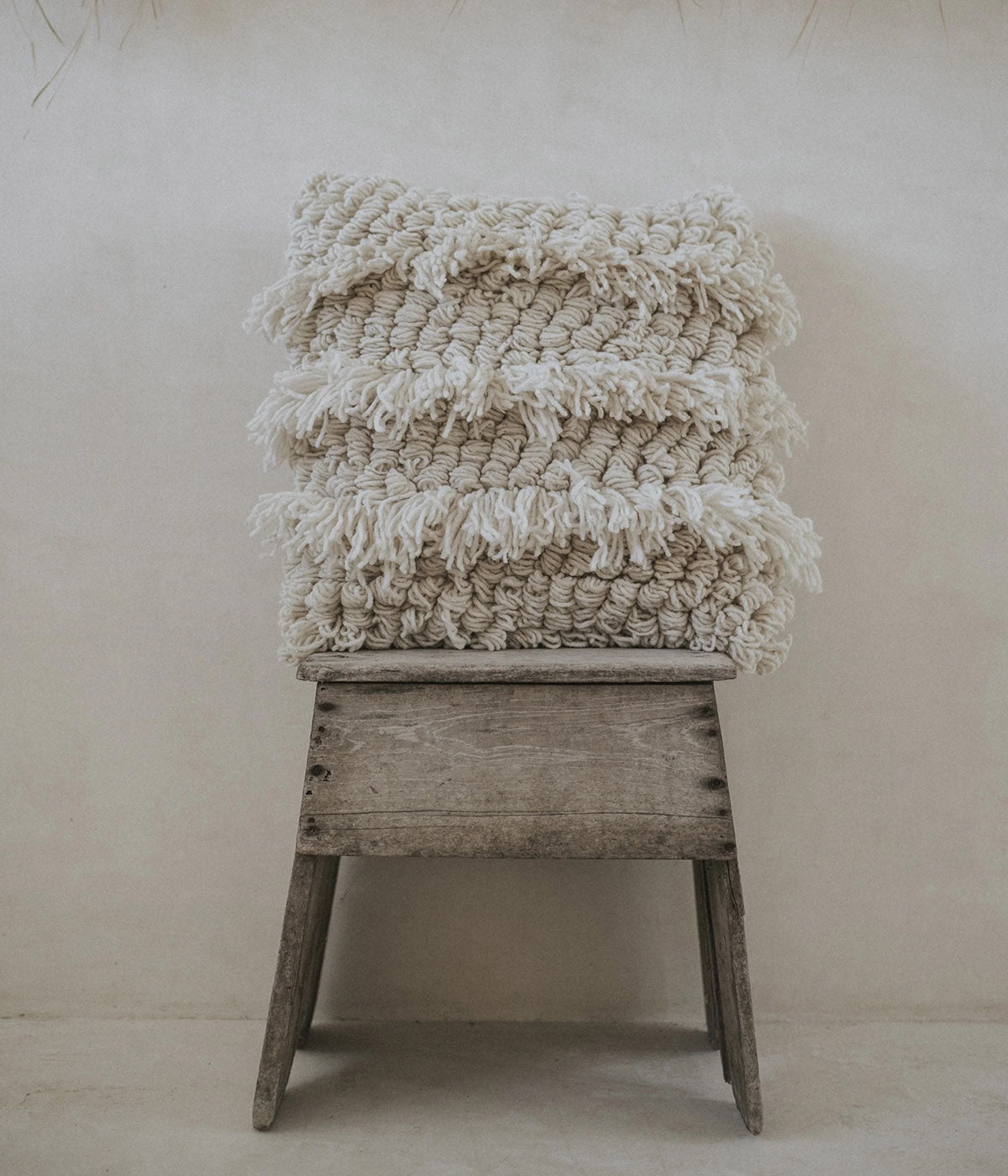 Ivory pillow with three-dimensional looped fringe texture
