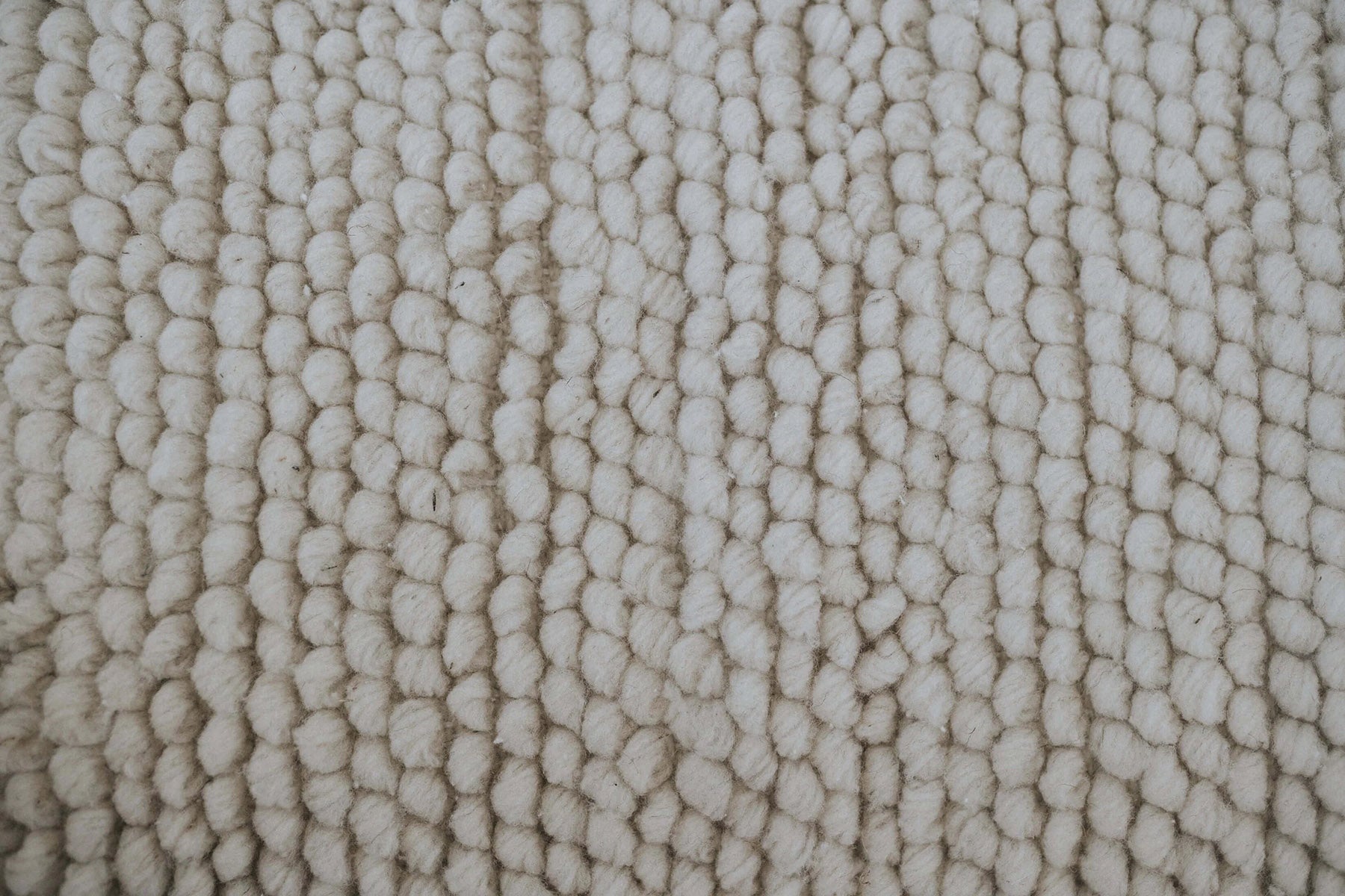 Wool throw pillows with small hand-formed nubs across the full face