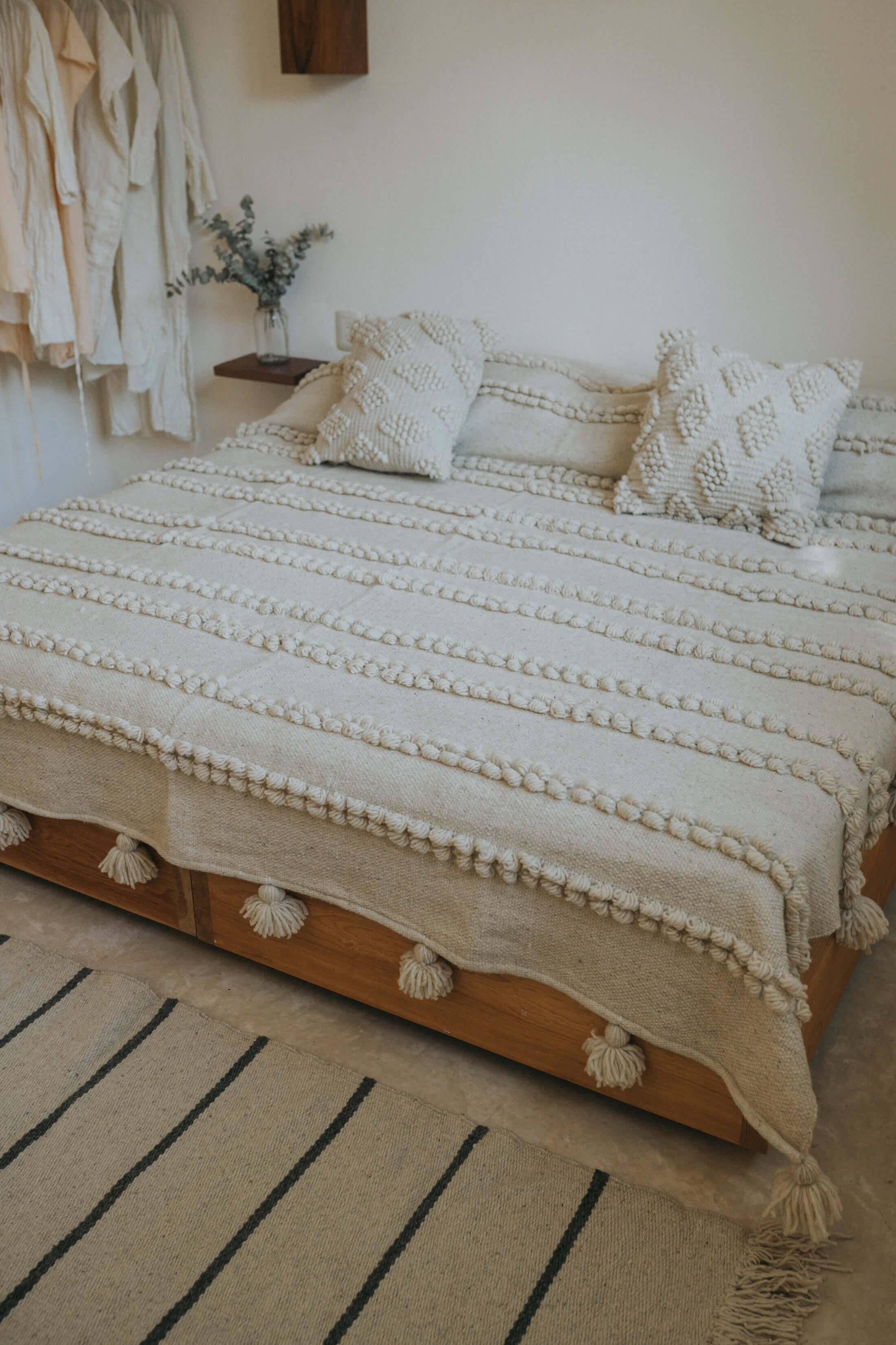 Sustainable wool blanket with hand-spun pompom texture