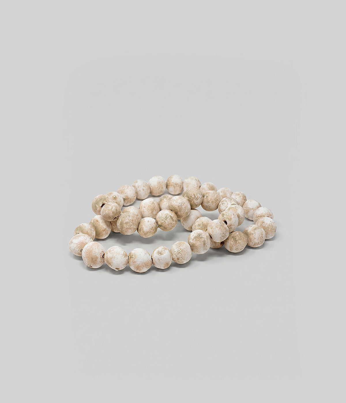 White patina decorative beads strung on cord for display