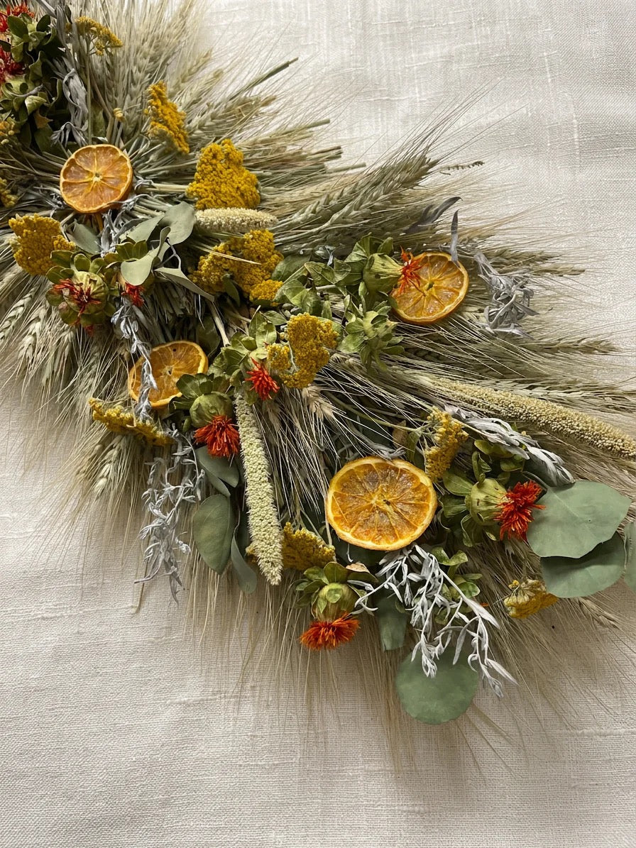 Table centerpiece with dried flowers, eucalyptus, and citrus slices