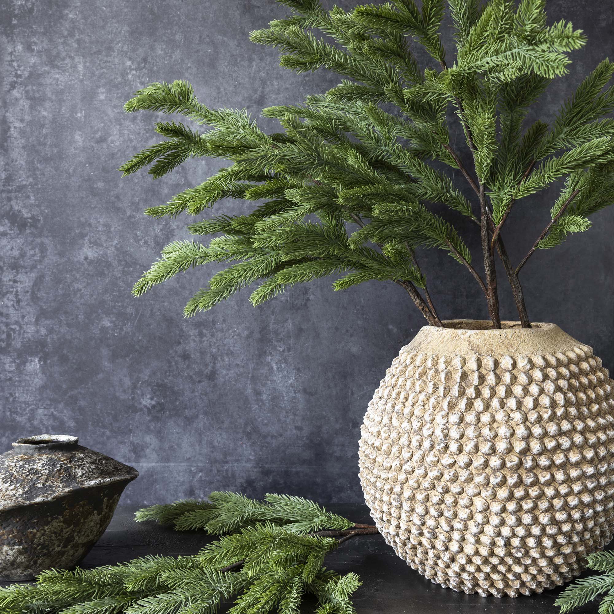 Decorative artificial pine stem with soft green color and layered detail arranged
