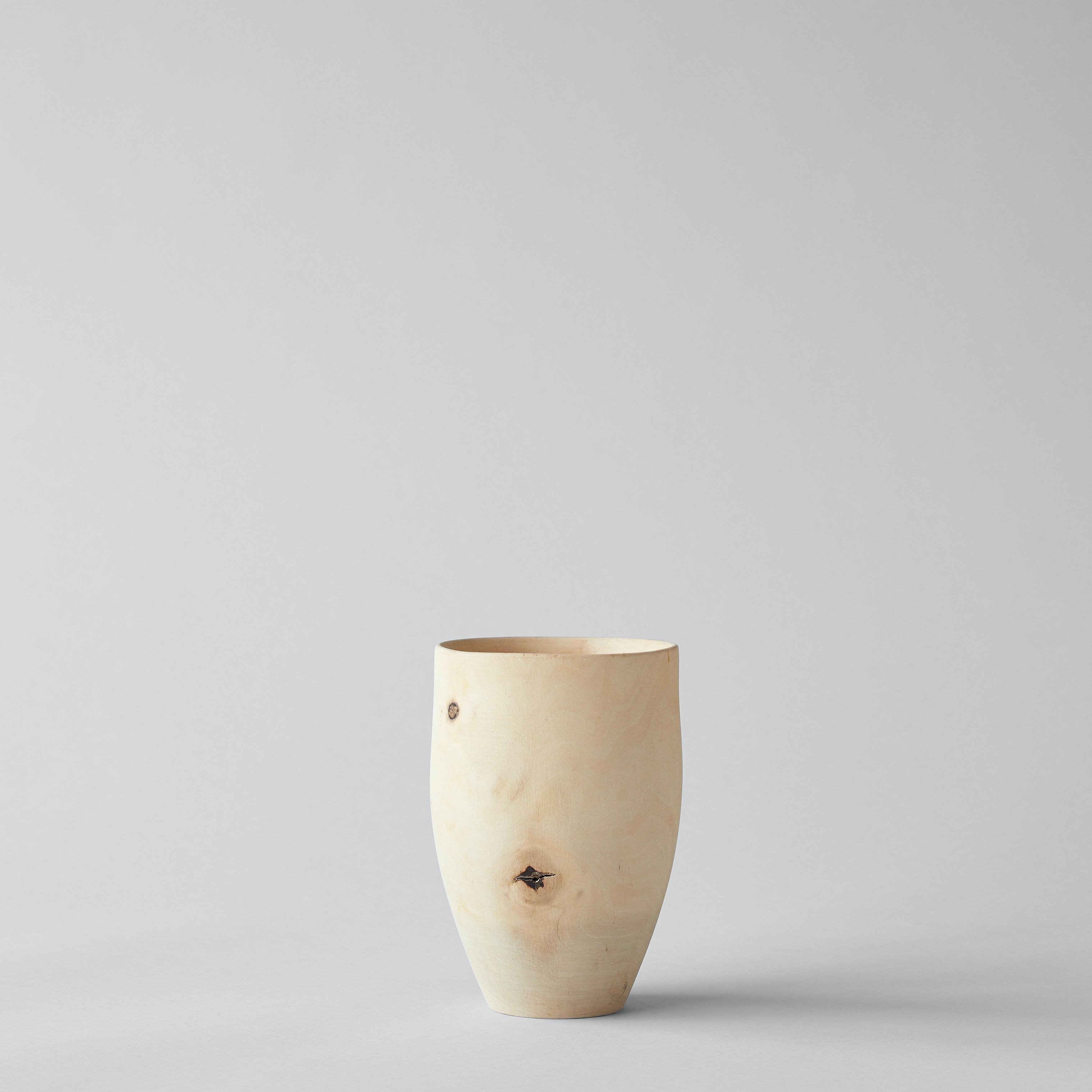 Hand-carved walnut vase with natural wood grain and knots