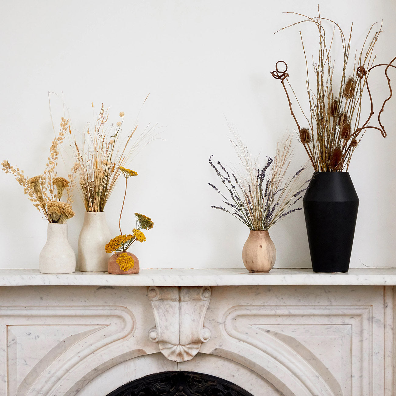 Rounded white tadelakt vase on a mantel with natural light