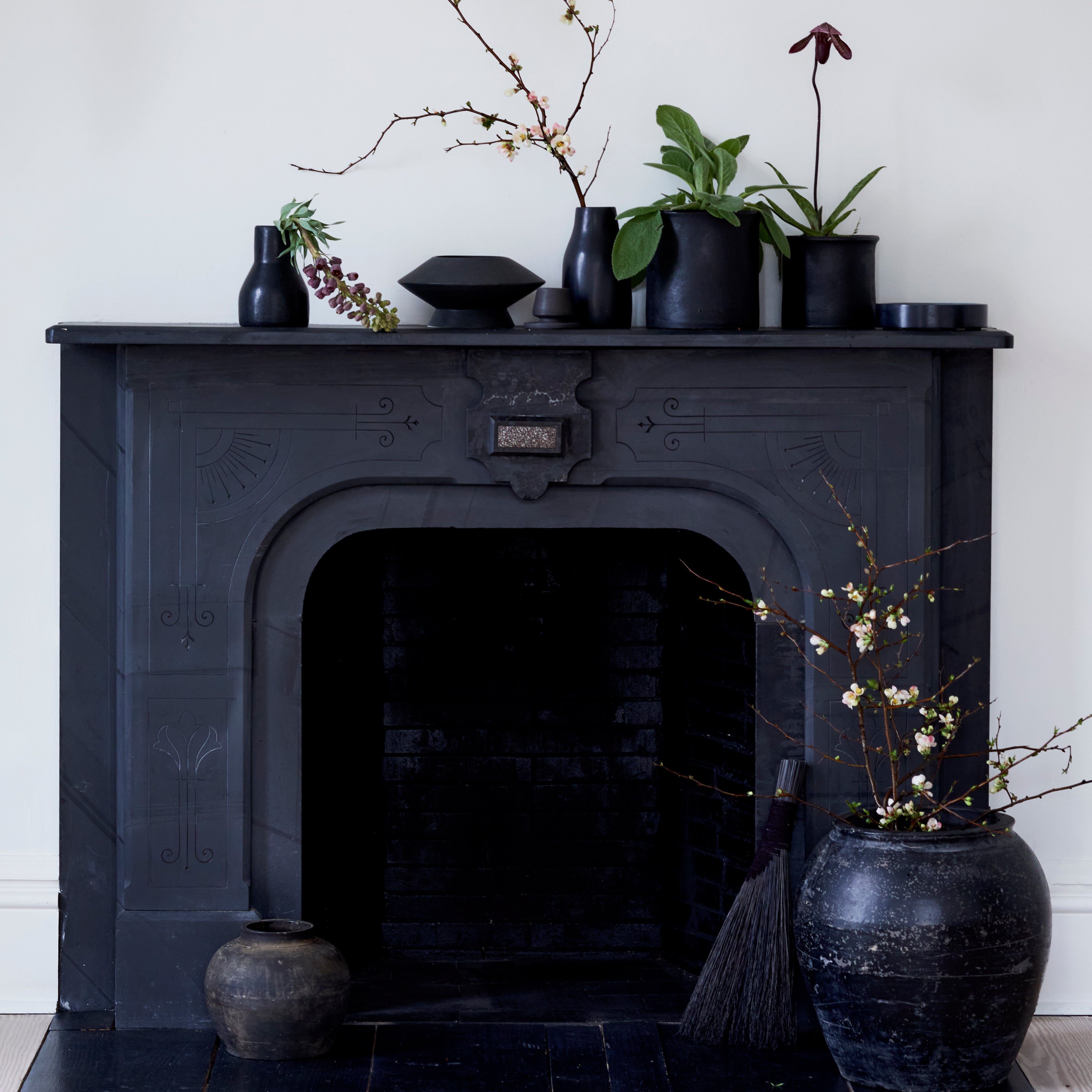 Handcrafted black tadelakt vase styled on a black mantel