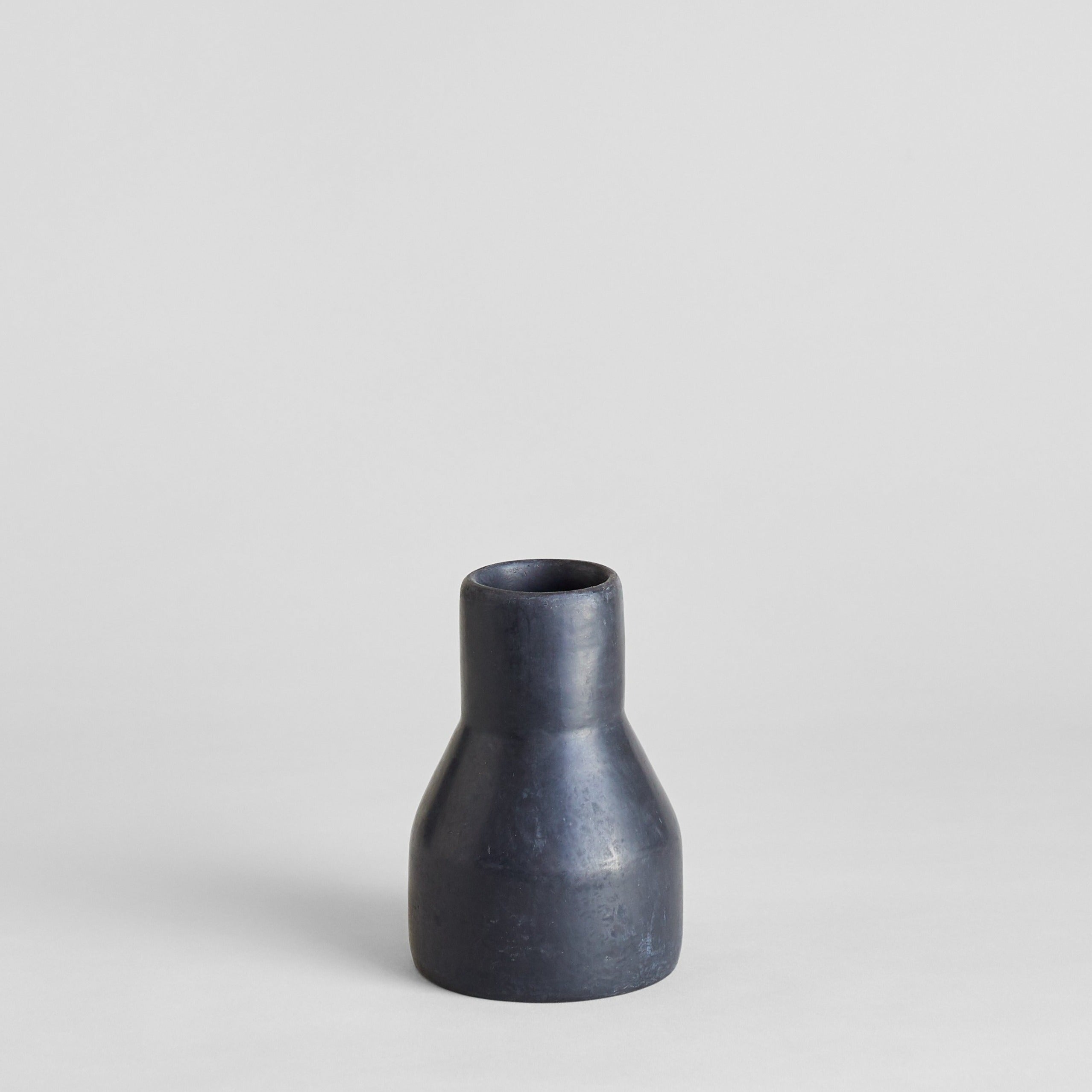 Hand-thrown short black clay vase with smooth stone-like surface
